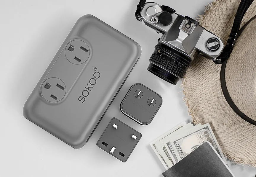 SOKOO compact voltage converter with UK and US/AU plug adapters, a camera and a sun hat